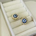 BRINCO OLHO GREGO C/ PEDRAS BANHO DOURADO